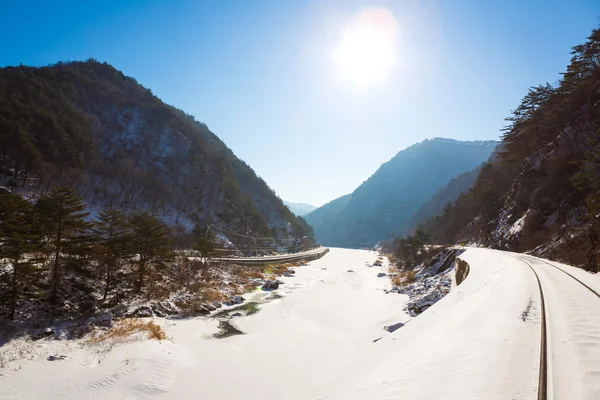 铁路线通过冬季积雪与阳光 — 图库照片