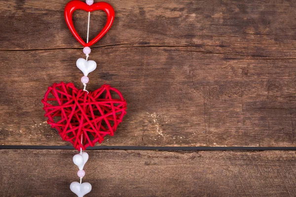 Corazón rojo colgando sobre fondo de madera vieja . —  Fotos de Stock