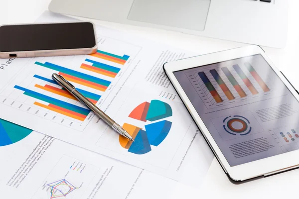 Finanční grafy na stůl s tabletu a pera — Stock fotografie
