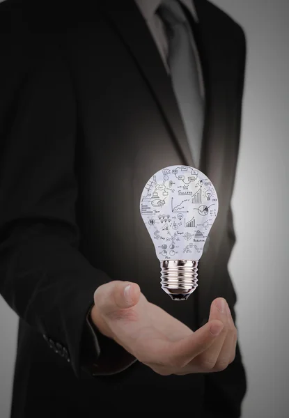 Business man holding light bulb with business concept inside — Stock Photo, Image