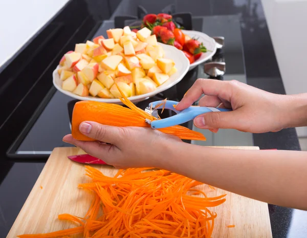 Cocinar verduras y ensalada de frutas en la cocina — Foto de Stock
