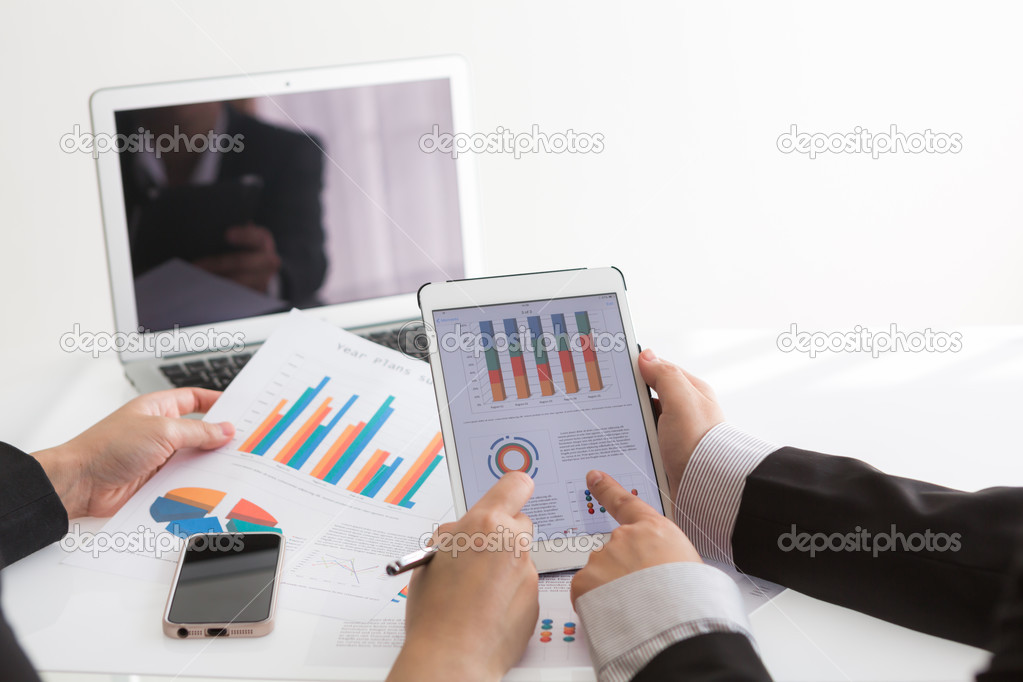 Close-up of business team using digital tablet with financial di