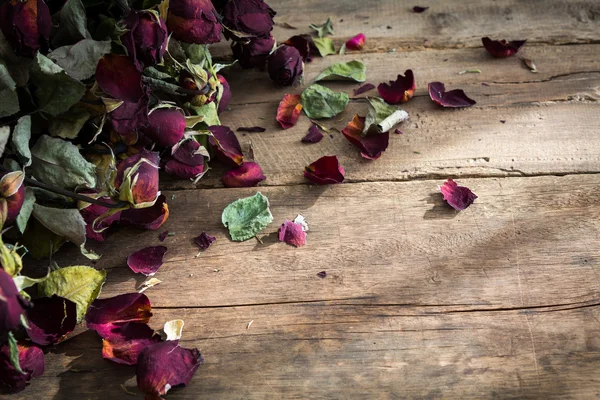 Сушеная роза на старом деревянном фоне — стоковое фото