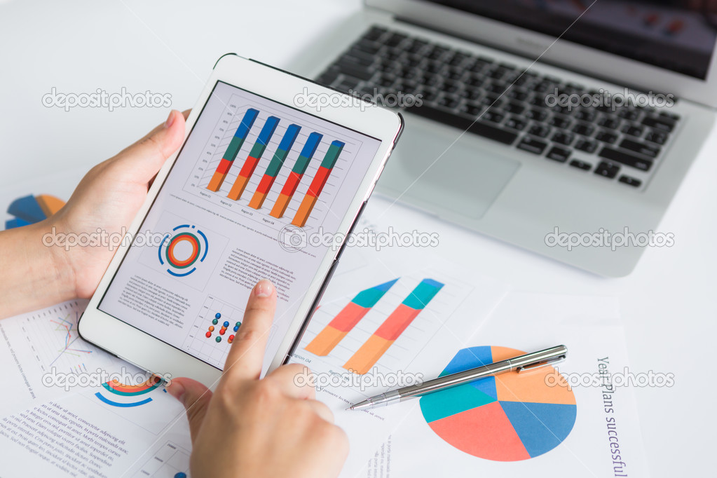 Close-up of business person using digital tablet with financial