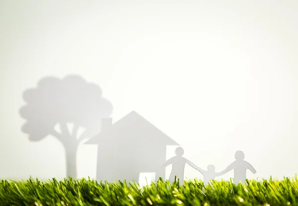 Papierschnitt der Familie mit Haus und Baum auf frischem Frühlingsgrün gr — Stockfoto