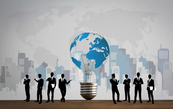 Business people silhouettes with bulb and world map — Stock Photo, Image