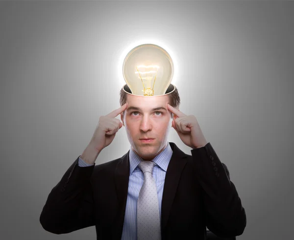 Porträtt av ung affärsman tänkande med glödlampa ut från — Stockfoto