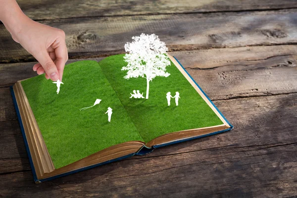 Corte de papel de los niños juegan en el libro de hierba verde — Foto de Stock