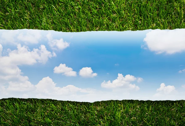 Ripped paper on green grass and blue sky — Stock Photo, Image