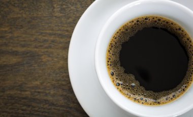 ahşap masa üzerinde beyaz fincan kahve