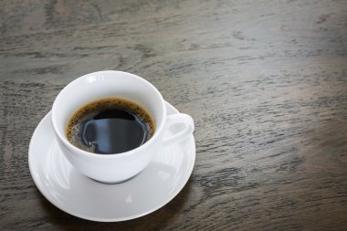 ahşap masa üzerinde beyaz fincan kahve