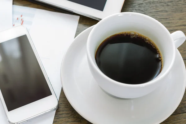 Laptop, tablet, smartphone e xícara de café com documentação financeira — Fotografia de Stock