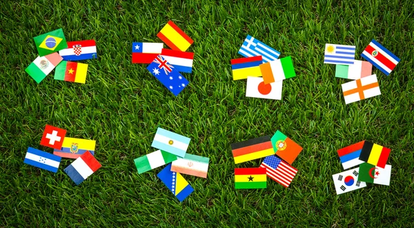 Corte de papel de bandeiras na grama para o campeonato de futebol 2014 — Fotografia de Stock