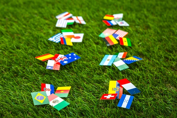 Corte de papel de bandeiras na grama para o campeonato de futebol 2014 — Fotografia de Stock