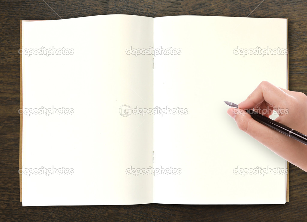 Hand writing in open book on table