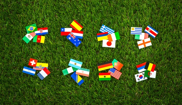 Corte de papel de bandeiras na grama para o campeonato de futebol 2014 — Fotografia de Stock