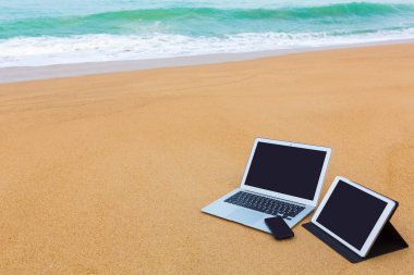 dizüstü bilgisayar, tablet ve yaz aylarında sahilde smartphone