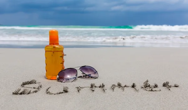 Sunscreen  lotion and dark glasses on the beach  for summer time — Stock Photo, Image