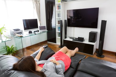 Modern ev ofis comp ile TV izlemek iş genç kadın