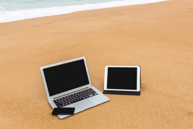 dizüstü bilgisayar, tablet ve yaz aylarında sahilde smartphone