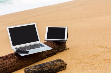 dizüstü bilgisayar, tablet ve yaz aylarında sahilde smartphone