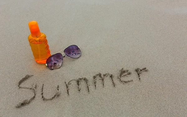Loção protetor solar e óculos escuros na praia para a hora de verão — Fotografia de Stock
