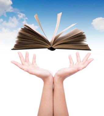 Women hand holding book over blue sky clipart