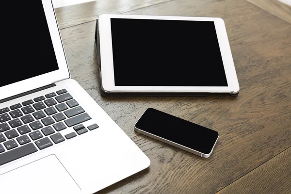 Ноутбук с планшетом и смартфоном на столе — стоковое фото