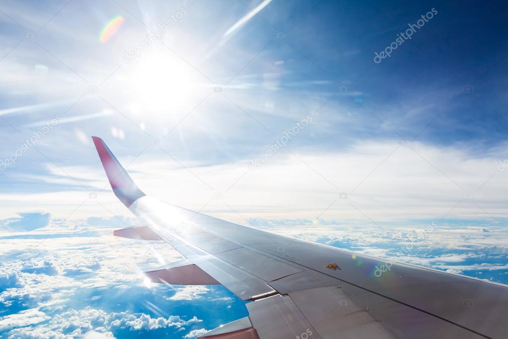 Wing of an airplane flying above the clouds