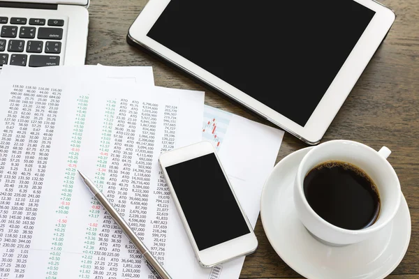 Portátil, tableta, teléfono inteligente y taza de café con documentación financiera — Foto de Stock