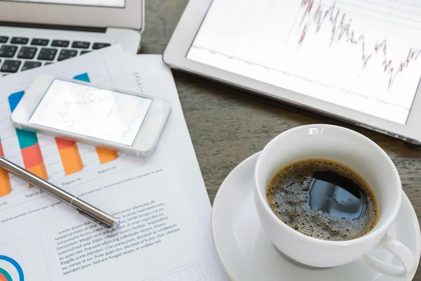Laptop, tablet, smartphone e tazzina da caffè con documenti finanziari — Foto Stock