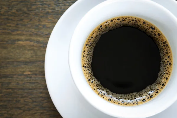 Koffie in witte cup op houten tafel — Stockfoto