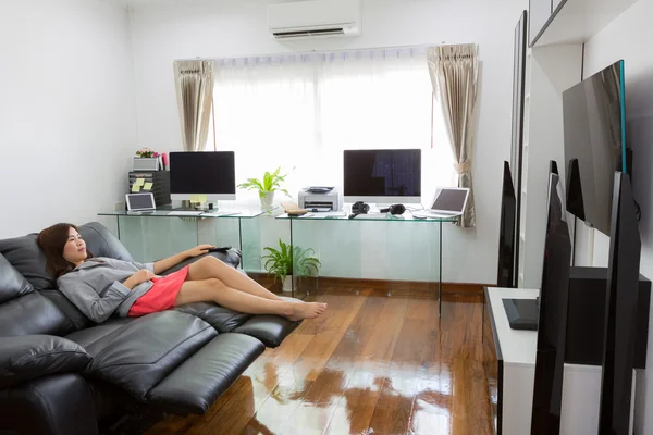 Obchodní mladá žena sledování televize v moderní domácí kanceláři s comp — Stock fotografie