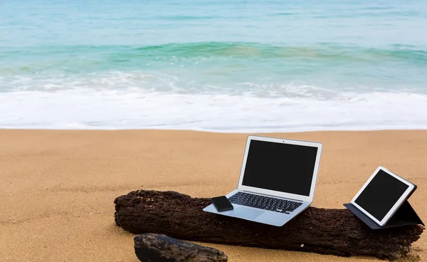 Ordinateur portable, tablette et smartphone sur la plage en été — Photo