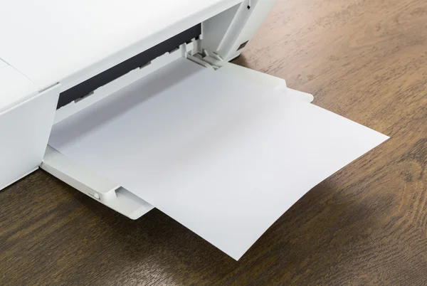 Impresora con papel en blanco sobre una mesa de madera —  Fotos de Stock