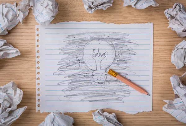 Borrado a lápiz y bombilla dibujada a mano sobre papel con pa arrugado — Foto de Stock