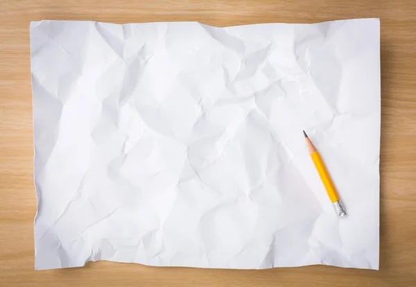 White  crumpled paper with pencil on a wooden desk — Stock Photo, Image