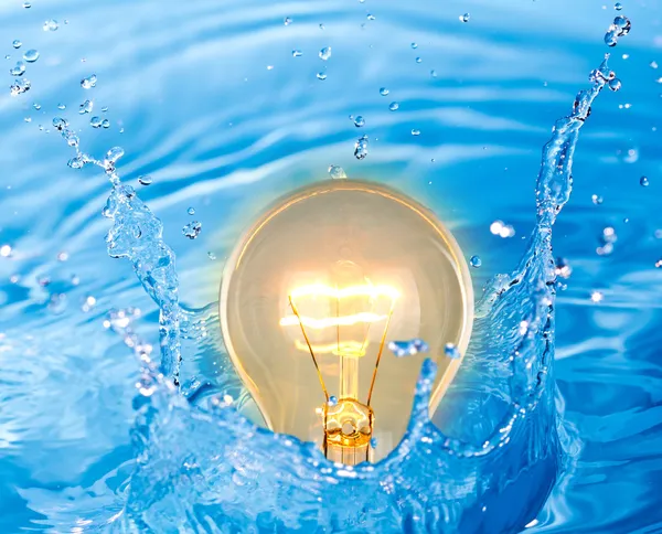 Lâmpada de luz amarela brilhante da ideia na água — Fotografia de Stock