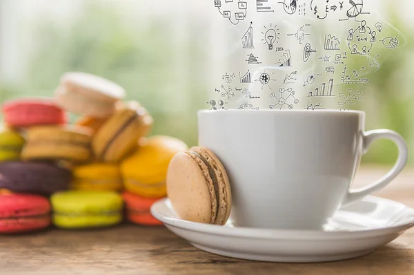Tasse à café et macarons colorés français avec graphique d'affaires sur s — Photo