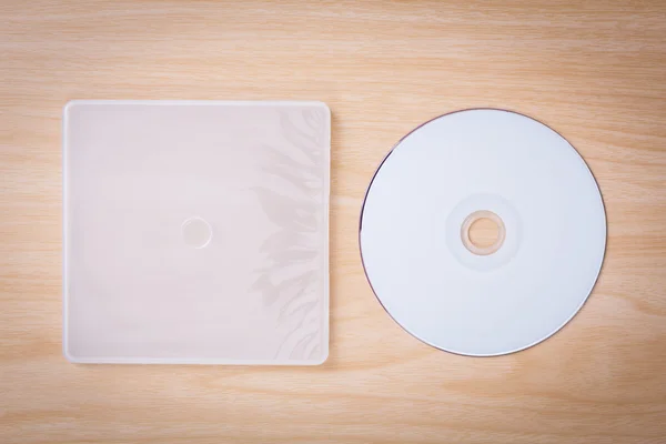 Blank compact disc with cover on wood background ground — Stock Photo, Image