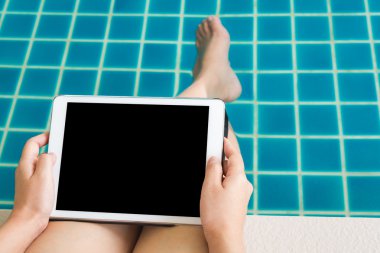 Yüzme havuzunda oturuyor tablet ile çalışan kadın
