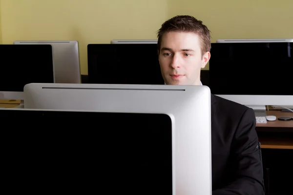 Ділова людина на робочих місцях в комп'ютерній кімнаті — стокове фото
