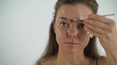 Genç ve güzel bir kız yüzüne şeffaf bir nemlendirici maske takıyor..