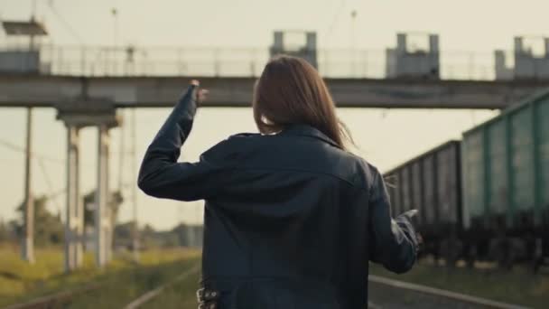 Hermosa filmación cinematográfica con una joven bailando en el ferrocarril. — Vídeos de Stock