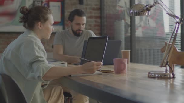 Los amigos están trabajando juntos en un proyecto común, sonriendo y riendo. — Vídeos de Stock