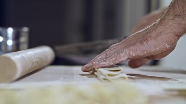 Close-up van een chef-kok die spaghetti snijdt. Close-up van pastadeeg. — Stockvideo