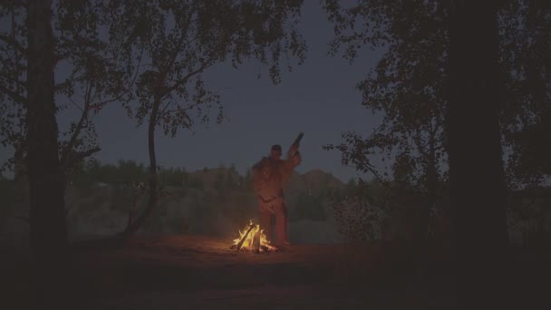 Un chamán con un tambor salta alrededor del fuego con ropa para la ceremonia. — Vídeos de Stock
