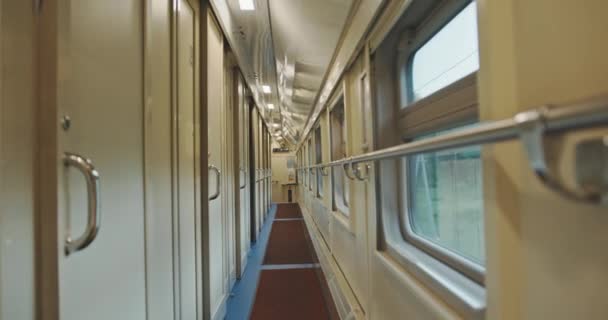 A young man with mugs of coffee enters the train compartment. — Stock Video
