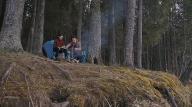 Bir sonbahar günü, sevgi dolu turistler ateşin yanında oturur ve demir bardaklardan çay içerler..