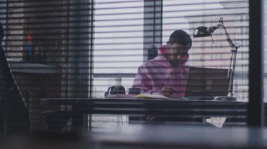 Genç, yakışıklı bir adam çalışma odasında çalışıyor..